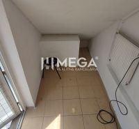 A narrow space with a radiator, a chair, and tiles in commercial premises.