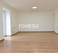 A spacious room with a wooden decor floor in a 2-room apartment.
