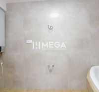 A bathroom with a bathtub and a boiler, tiles and flooring with a wooden decor in a 2-room apartment.