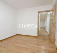 A room in a 2-room apartment with a wooden decor floor and open doors.
