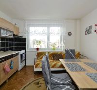 A kitchen in a family house with a kitchen unit and a dining table, a floor with a wooden decor.