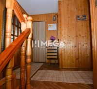 Interior of a family house with a staircase, wooden paneling, and a floor with a wooden decor.