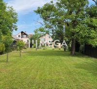 A garden at a family house in Lackovce with a well-maintained lawn and trees.
