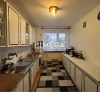 A kitchen in a family house with equipment, white cabinets, and a carpet.