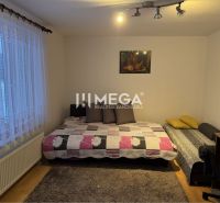 A room with beds and a table in a family house, floor with wooden decor.