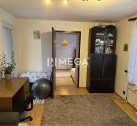 A room with a desk, carpet, and wood-patterned flooring in a family house.