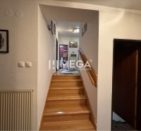 A hallway with stairs and a wooden decor floor in a family house.