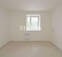 An empty room in a 3-room apartment with white walls and a bright window.