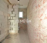 Interior of a family house with brick walls and a small window in the bathroom.
