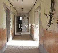 The interior of an unfinished family house with exposed electrical wiring and unplastered walls.
