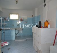 Storage room in a family house with blue tiles and simple furnishings.
