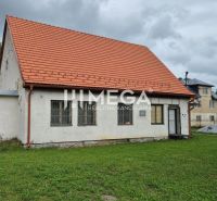 Building in Zboj with a red roof and grassy surroundings. Commercial spaces available.