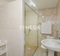 A bathroom in a family house with pink tiles, a shower, and a sink.