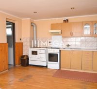 A kitchen in a family house with a wooden decor floor and wooden furniture.