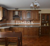 A kitchen in a family house with a wooden decor, kitchen unit, and dining table.