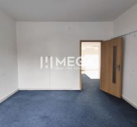 Commercial space with blue carpet and light wall, closed wooden door.