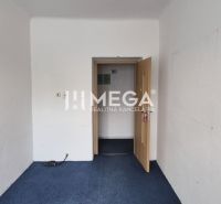 A white room with a blue carpet and open doors in a commercial space.