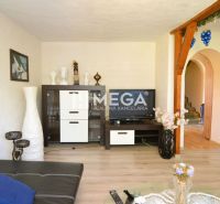 Living room in a family house with a wooden decor floor, wall with paintings and TV.
