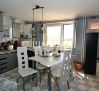 A kitchen in a family house with a dining area, light walls, and modern lighting.