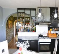 A family house kitchen with open shelves, glasses, and a wooden decor floor.