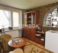 Living room in a family house with wooden floor decor and a stone wall.