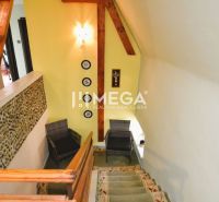 A staircase in a family house with wooden paneling and stone wall decoration.