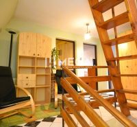 Wooden stairs, armchair, shelf, and green wall in a family house.