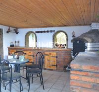 Family house with an exterior cover and seating area, Koškovce, featuring both brick and wooden architectural elements.