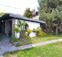 The exterior of a family house in Koškovce with a terrace and lush greenery in the garden.