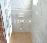 A bathroom with a wooden decor floor in a 2-room apartment, ready for equipment installation.