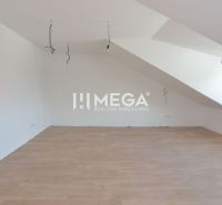 An attic room with a slanted ceiling and a wooden decor floor in a 2-room apartment.