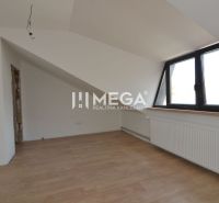 Attic room with white walls and a wooden decor floor in a 2-room apartment.
