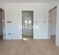 Interior of a 2-room apartment with a wooden decor floor, white walls, and a radiator.