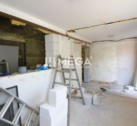 Production premises under construction with a ladder and building materials, floor with wooden decor.