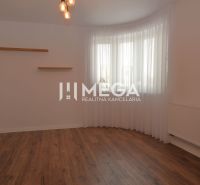 A room in a family house with a wooden decor floor, white walls, and curtains.