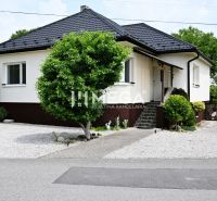 A family house in Udavské with a landscaped garden, a walkway, and ornamental shrubs.