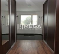 A hallway in a family house with a wooden decor floor and built-in wardrobes.