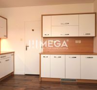 A kitchen in a family house with white cabinets, appliances, and a wooden decor floor.