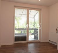 A room with a wooden decor floor, large window, radiator, mirror. Family house.