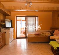 A room in a family house with wooden paneling, furniture, and decorations on the walls.