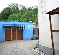 A family house on Sídlisko Poľana in Humenné with a blue garage and a paved yard.