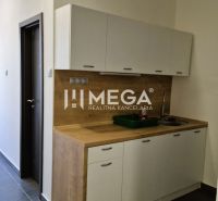 A kitchenette in the office with wooden decor and a large window.