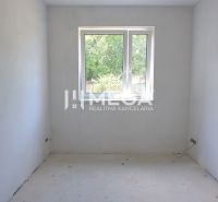An empty room in a family house with white walls and a window.