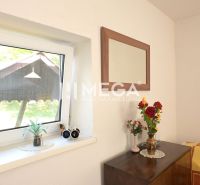 A bouquet and a mirror in a family house, minimalist decor and wooden furniture in the interior.