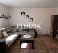 Living room with a sofa, table, and wooden decor flooring in a family house.