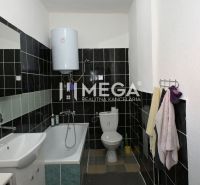 A bathroom in a family house with a bathtub, sink, and boiler, black and white tiles.