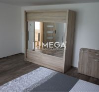 Bedroom with a mirrored wardrobe and a dresser in a family house with a wooden decor floor.