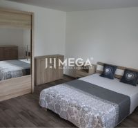 A bedroom in a family house with a wooden decor floor and wooden furniture.