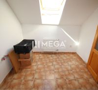 A small room with a skylight, tiles, and a radiator in a family house.