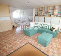 Living room in a family house with a corner sofa and tiles.